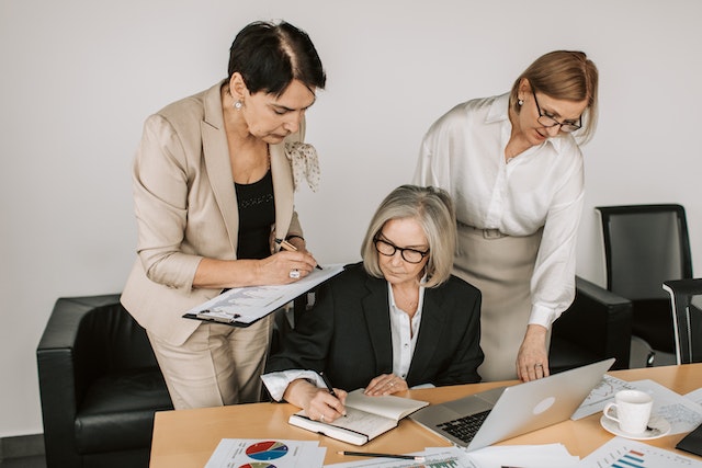 three property managers looking over various papers with stats and graphs on them